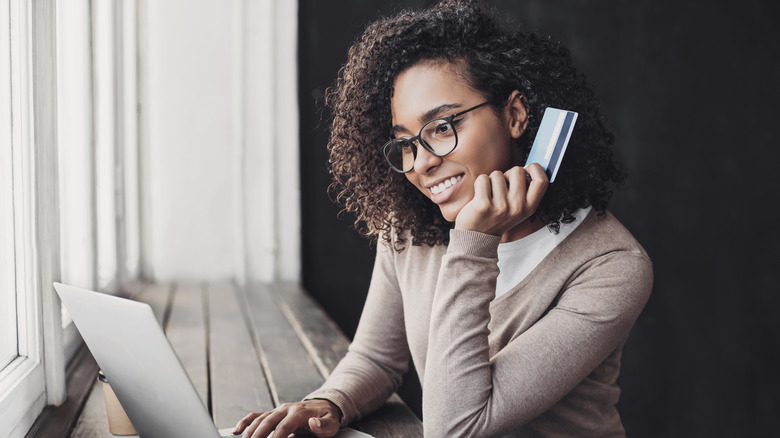 A woman holding a credit card 