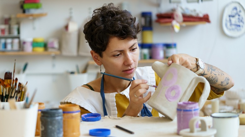 woman painting a piece of pottery