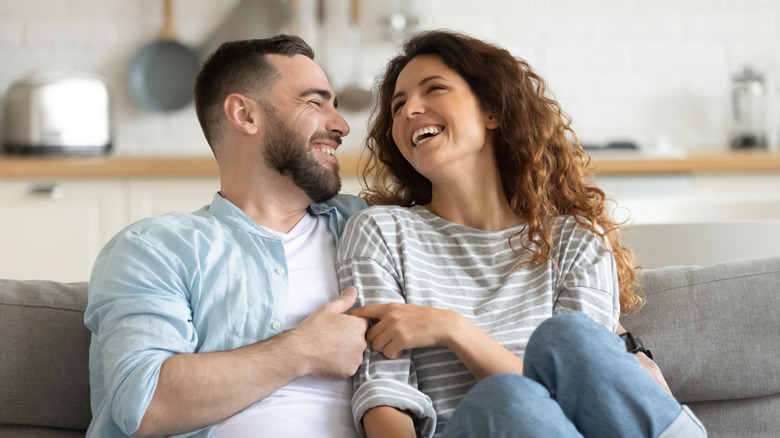 Couple laughing on couch 