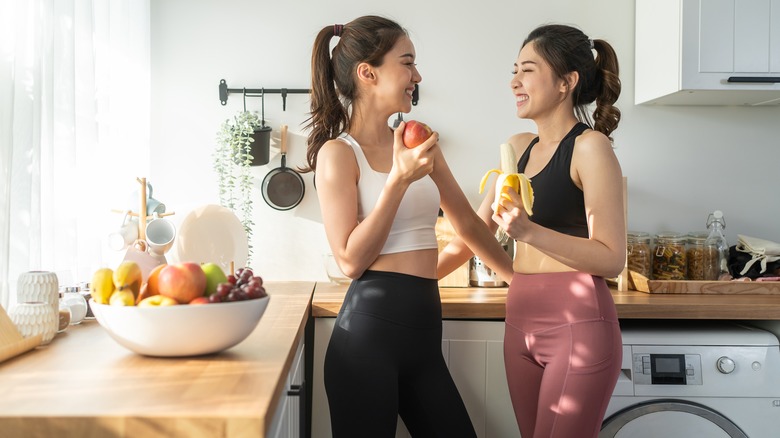Sisters standing in the kitchen together after a workout
