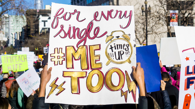 protestors marching, holding #metoo protest signs