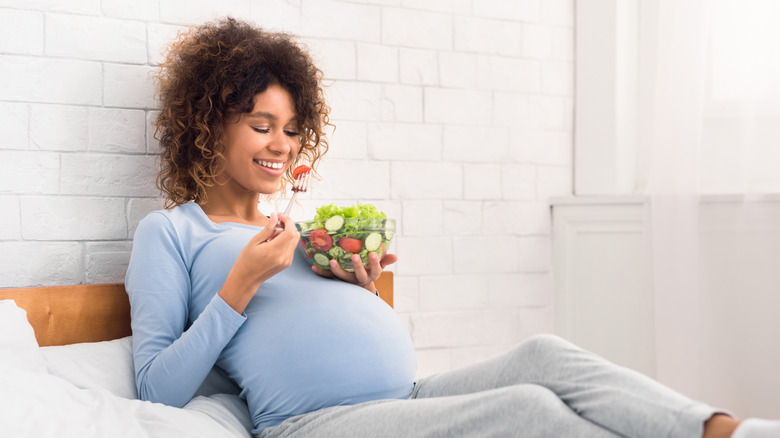 Pregnant woman eating salad