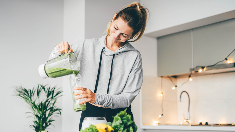 A woman pouring a smoothie 