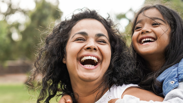 A woman happily spending time with a child. 