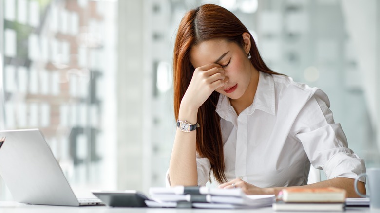 A woman is stressed at the office. 