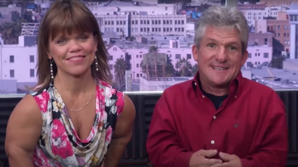 Little People, Big World's Matt and Amy Roloff in front of a cityscape