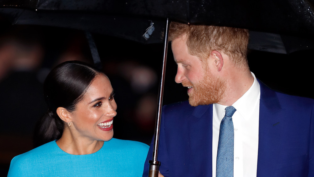 Prince Harry and Meghan Markle under an umbrella