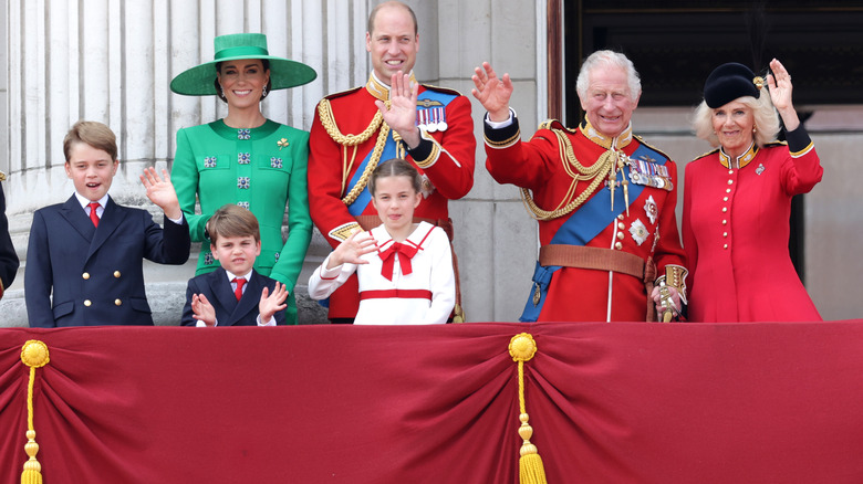 Senior royal members waving from the palace balcony