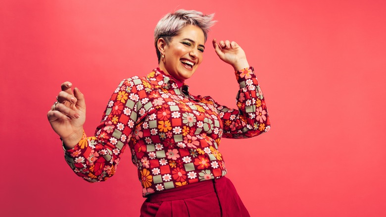 A woman smiling and dancing