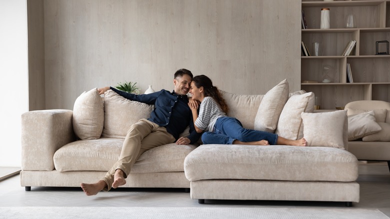 Man and woman snuggling on couch