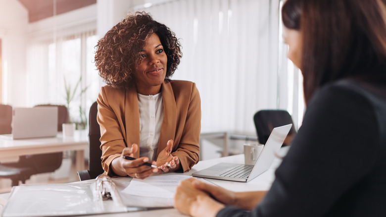 Woman sitting with colleague at work