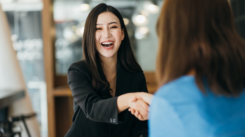 A woman shakes hands in an office 