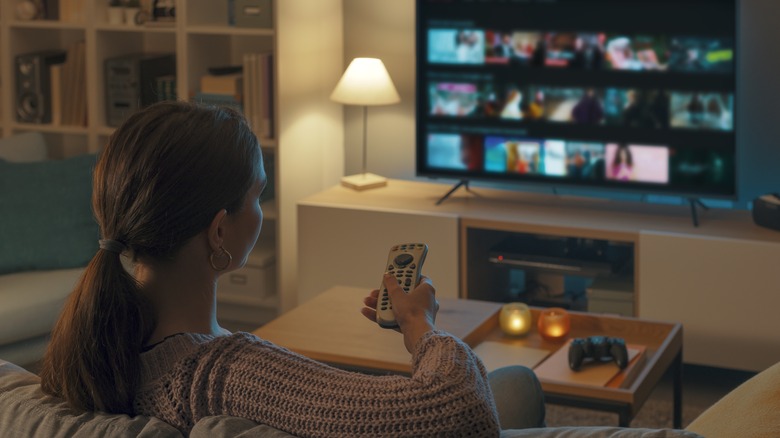 Woman unwinding at home watching TV