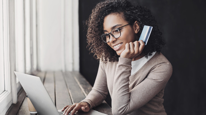 A woman holding a credit card 