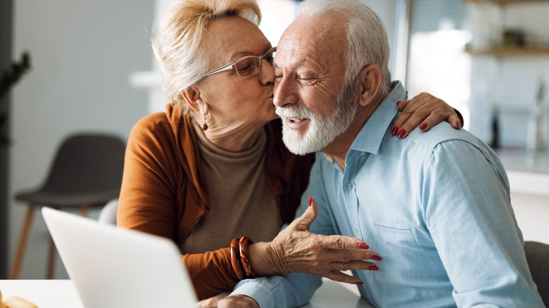 A woman kissing a man on the cheek. 