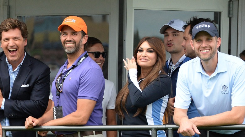 Kimberly Guilfoyle and Eric Trump smiling at golf tournament