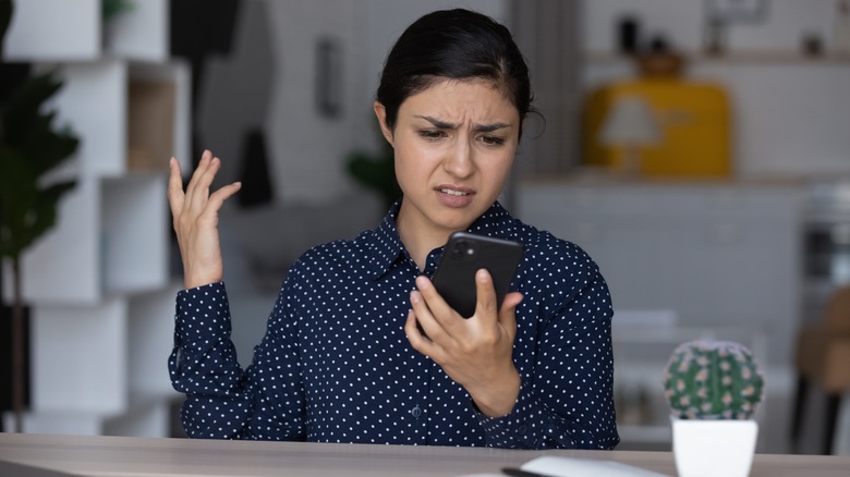 Angry woman looking at phone