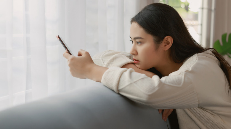 serious woman looking at phone