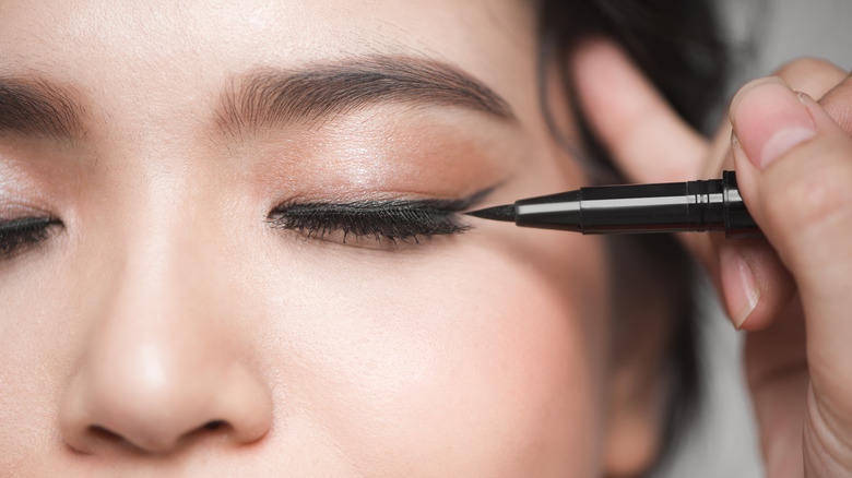 Woman applying eyeliner 