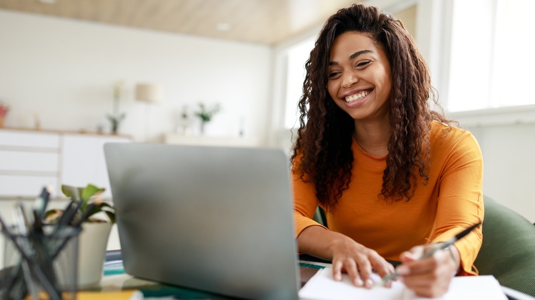 smiling woman looking at computer