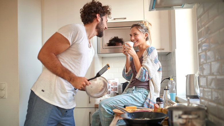 smiling couple cooking in kitchen