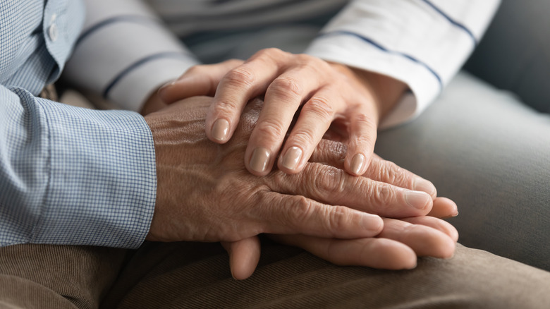 Old couple holding hands