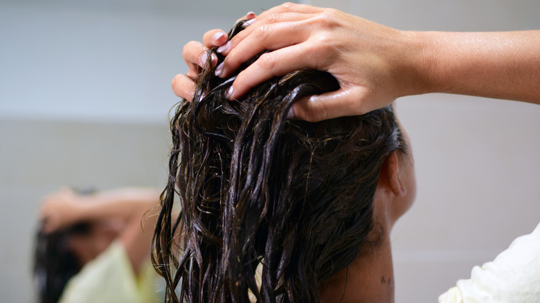 woman applying hair treatment