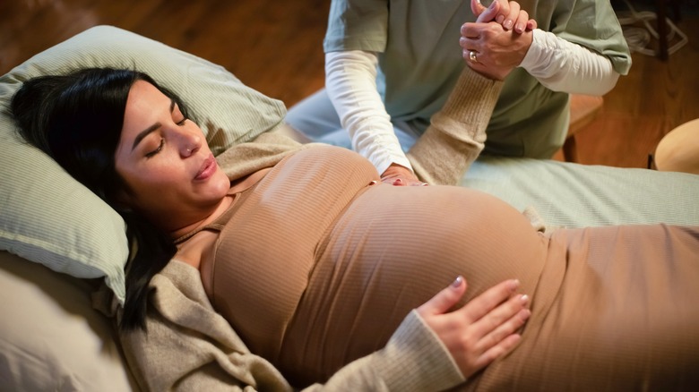 pregnant woman holding hands with doula