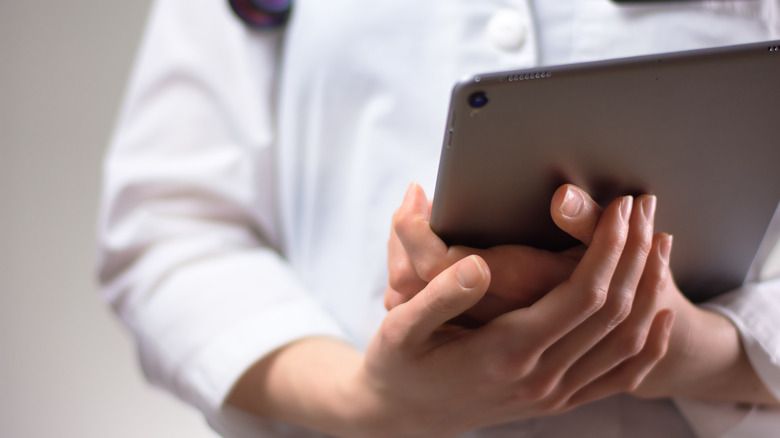 close up of tablet in hands of medical professional 