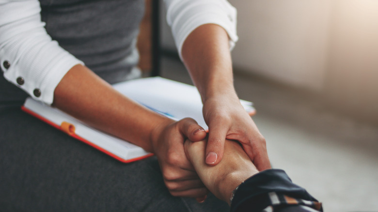 Therapist holding client's hand