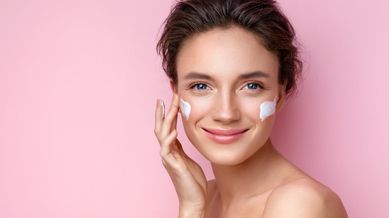 Woman applying moisturizer