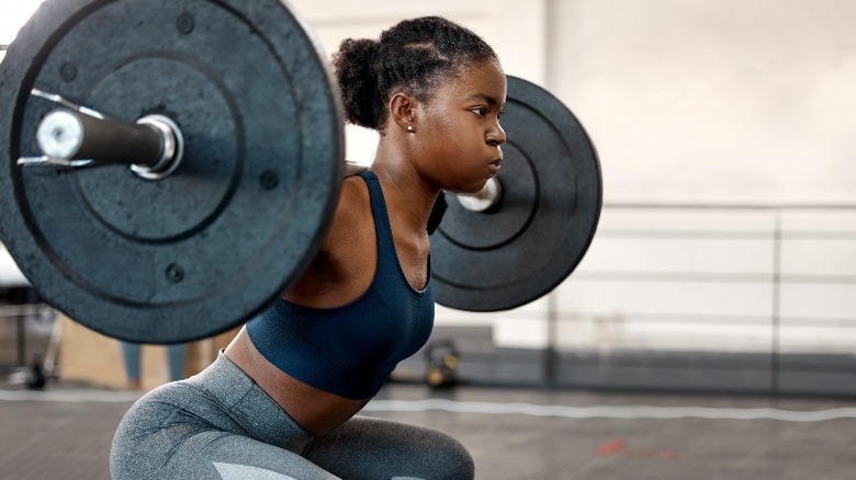 Woman lifts heavy barbell