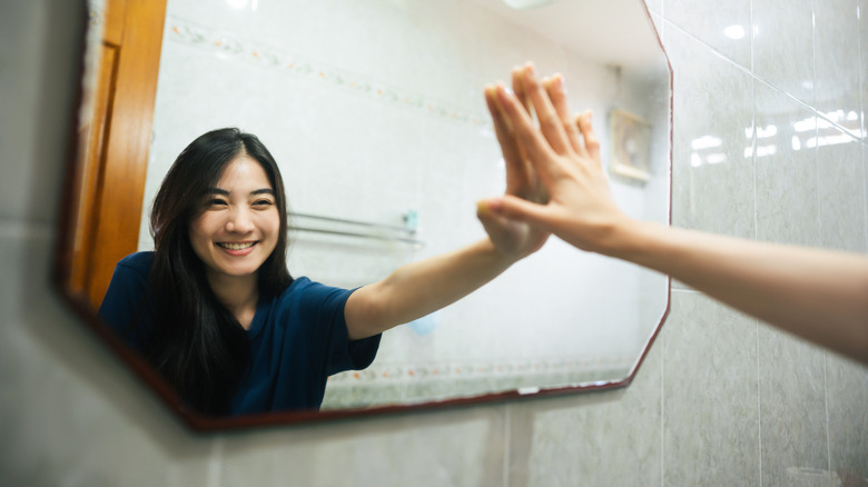 woman touching a mirror 