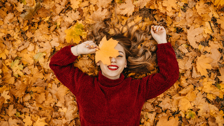 Happy woman in autumn leaves