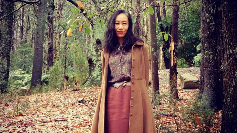 person wearing vintage neutral outfit in the woods