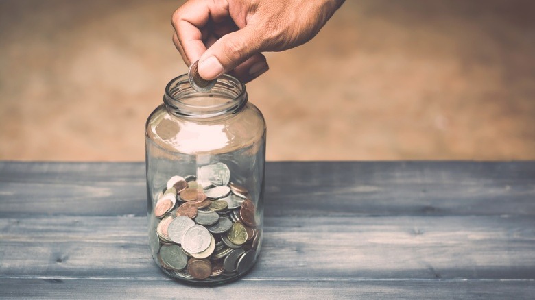 putting coins into savings