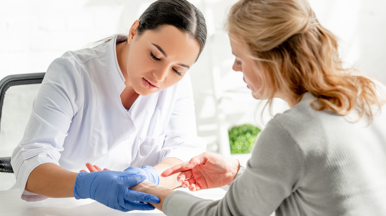 dermatologist looking at a woman's hands