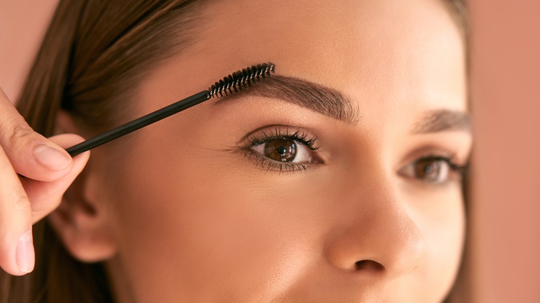 Woman brushing her eyebrows