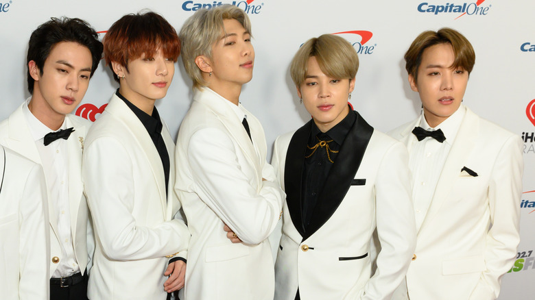 K-pop group BTS posing on red carpet in white tuxedos