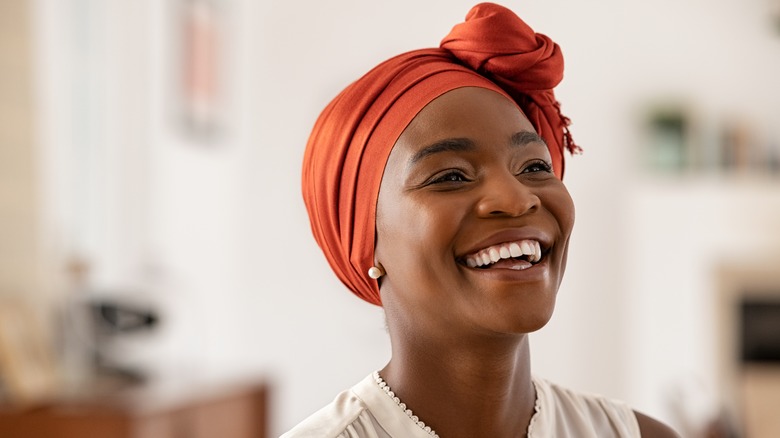 woman wearing orange headscarf smiling