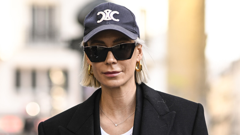 Woman in a black blazer wearing golden hoops