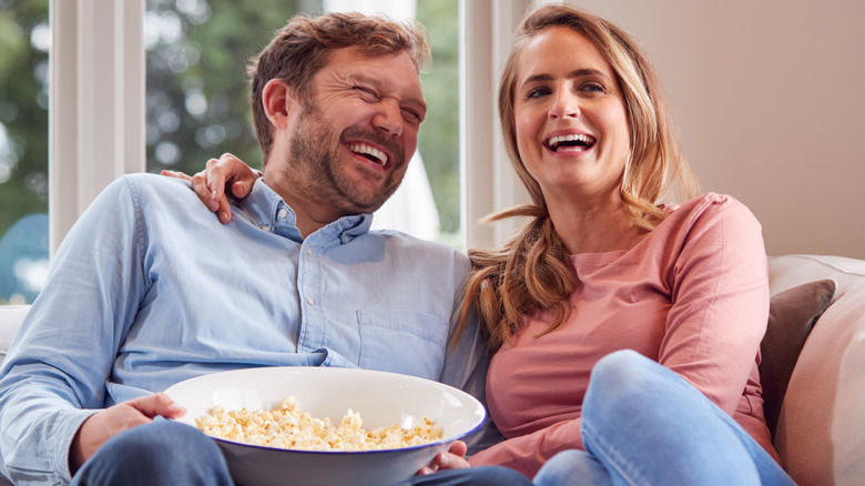 Couple laughing with popcorn