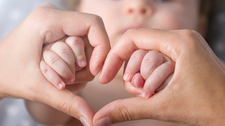 heart-hand gesture with baby