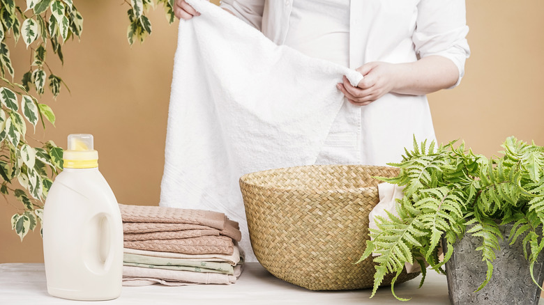 A person folding a white towel