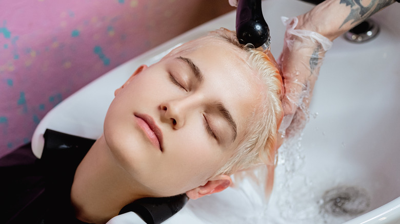 woman with pixie haircut getting her hair washed at a salon