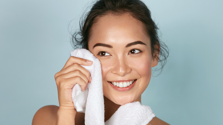 Woman wiping off face wash with towel