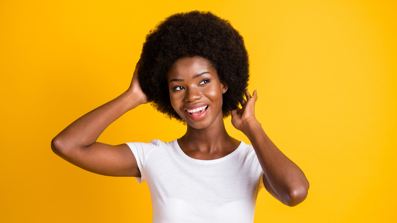 Black woman touching her Afro