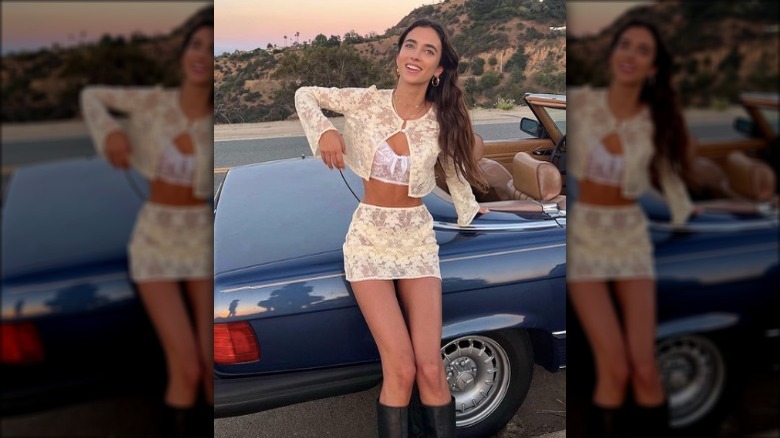 woman posing with vintage car during sunset