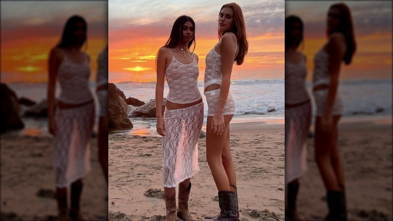 women posing on beach during sunset