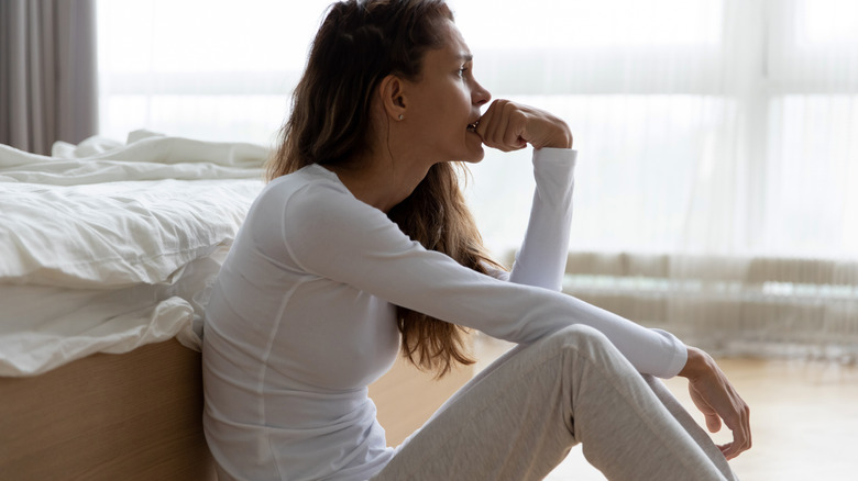 Anxious woman sitting on floor